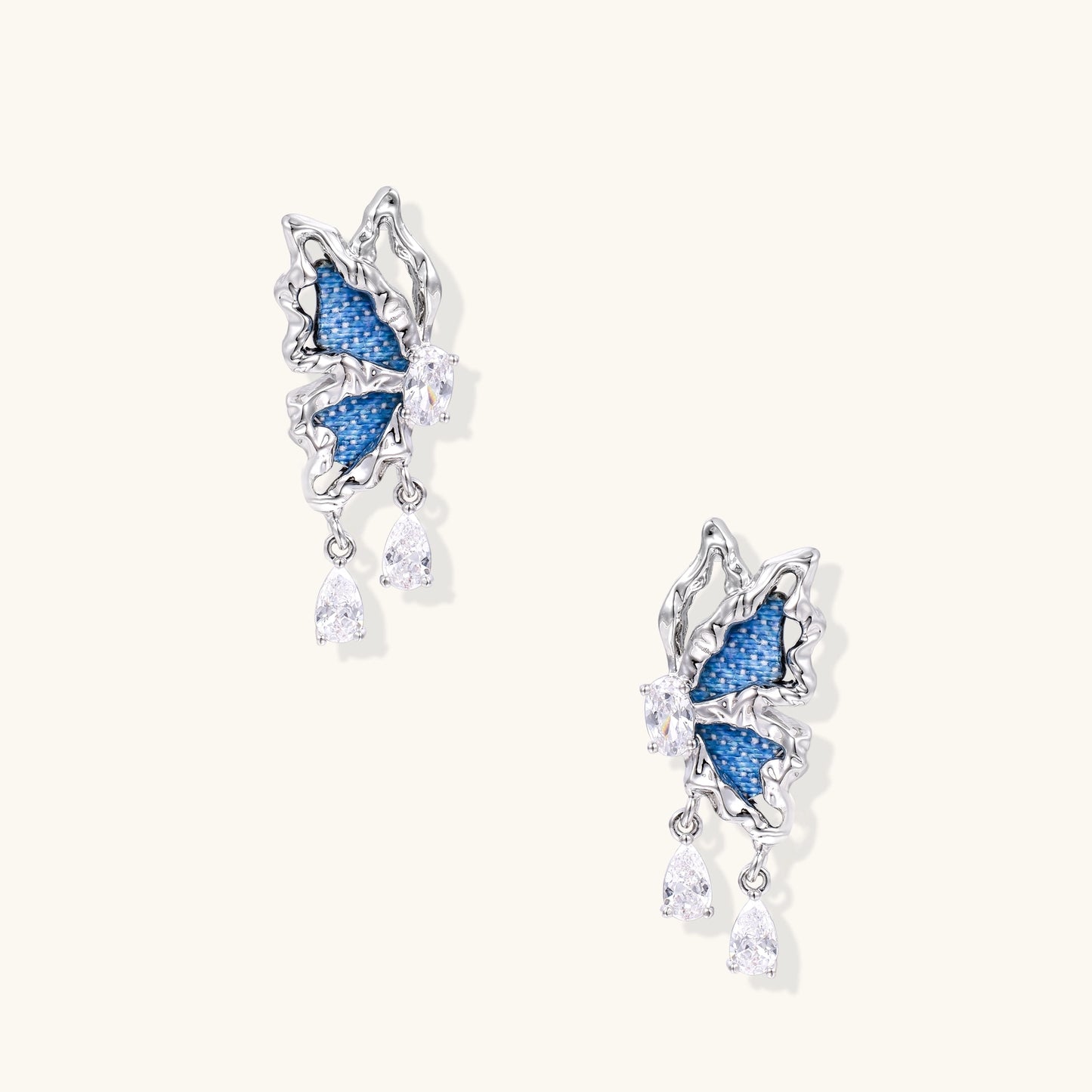 Gold-plated brass earrings featuring blue denim fabric insets and sparkling zirconia crystals with teardrop dangles