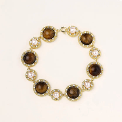 Ornate gold-plated bracelet with alternating brown tiger's eye stones and white freshwater pearls in crystal-accented settings