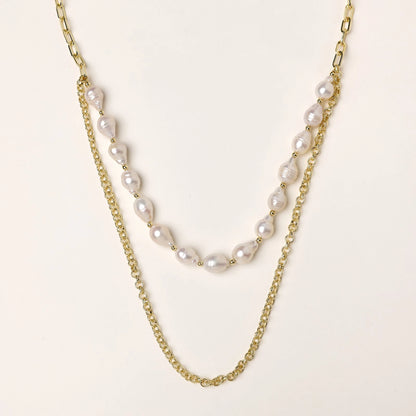 Layered gold chain necklace with irregular freshwater pearls on cream background, showing adjustable dual-strand design.