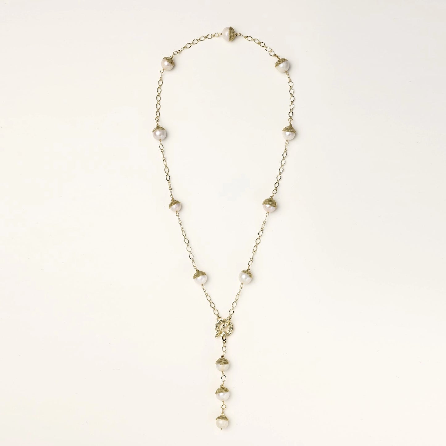 Long gold-plated lariat necklace featuring baroque pearls with metal caps arranged in elegant Y-shape design