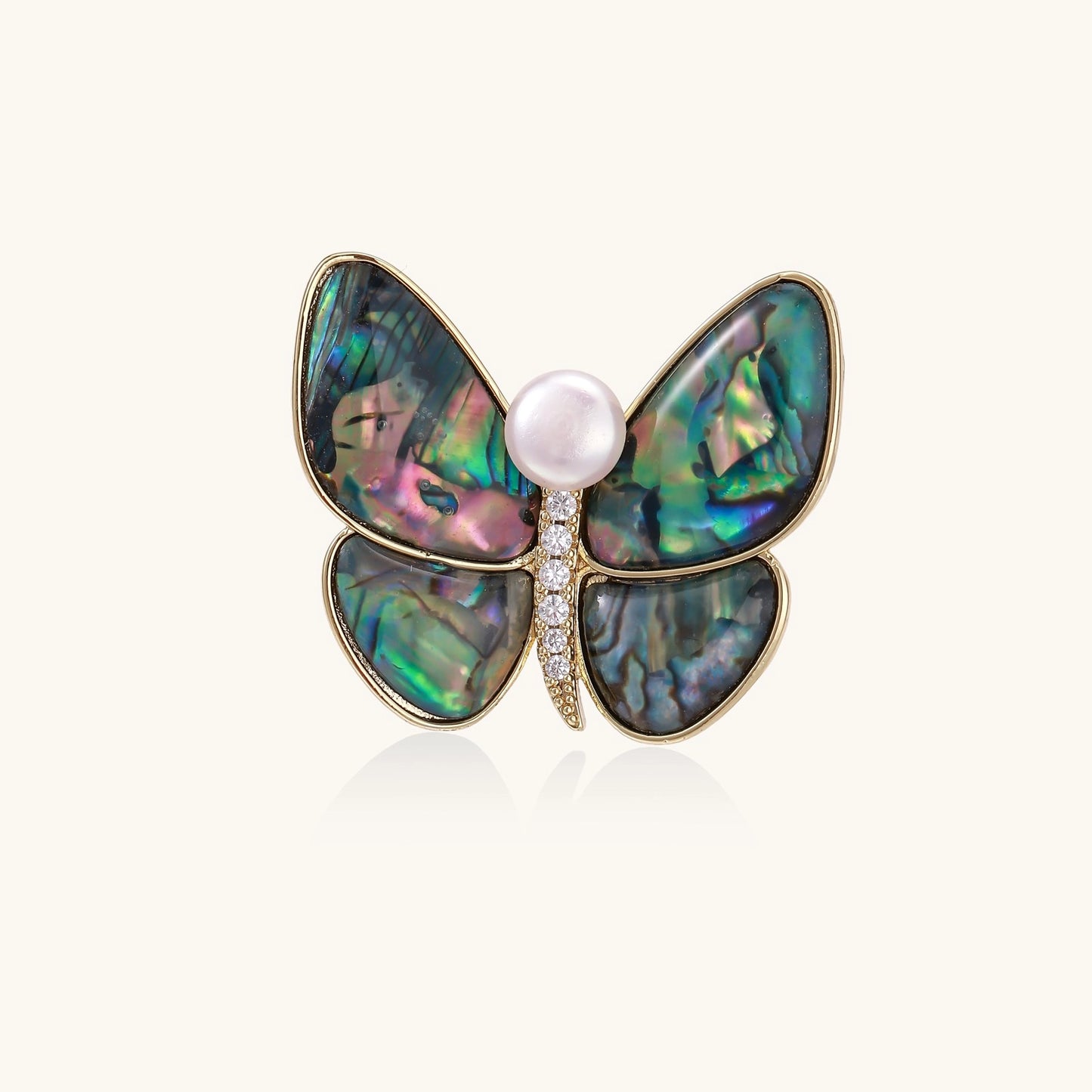 Iridescent abalone shell butterfly pin with central pearl and gold setting, showing rainbow color reflections