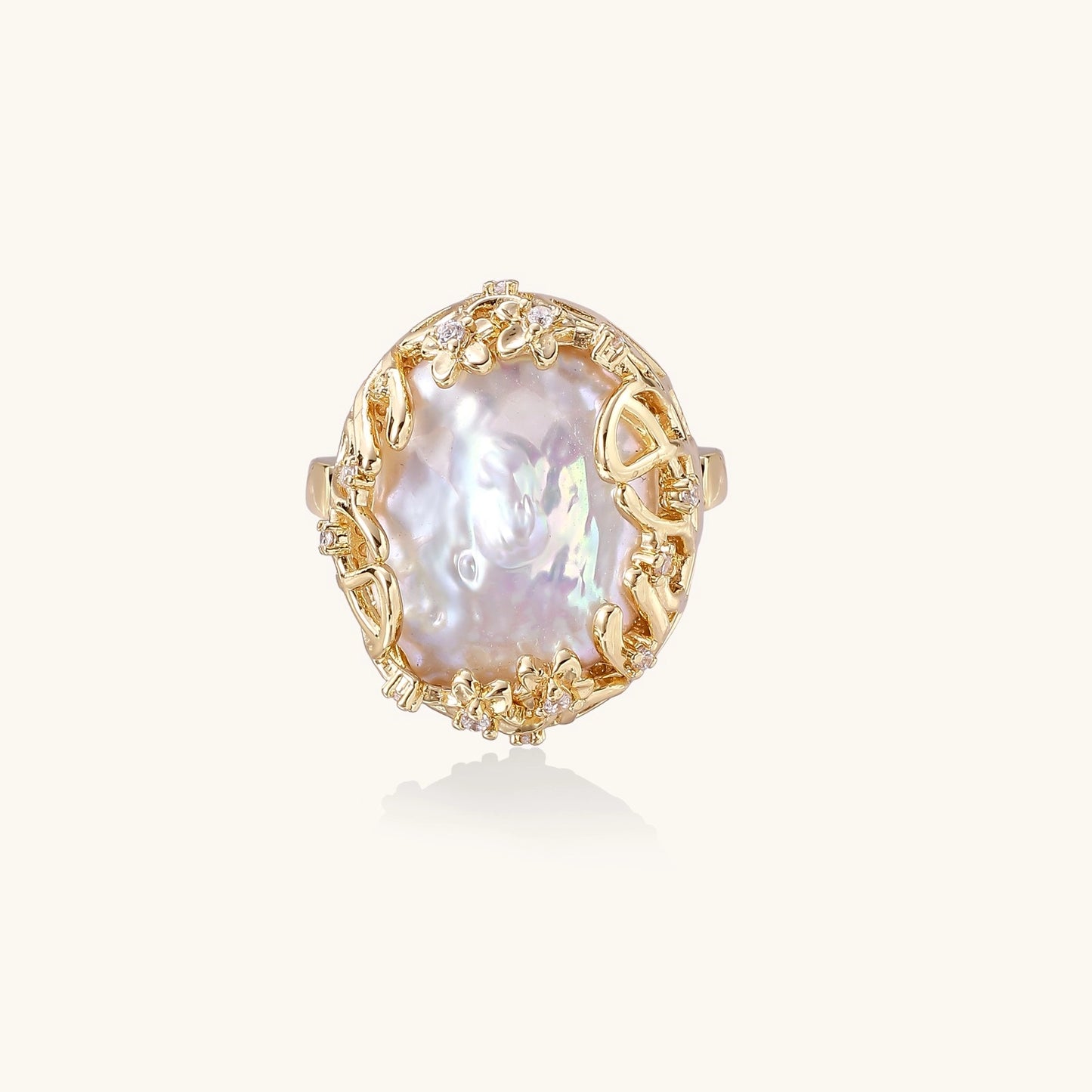 Ornate gold-plated ring with large baroque pearl in decorative vine-like setting with small crystal accents