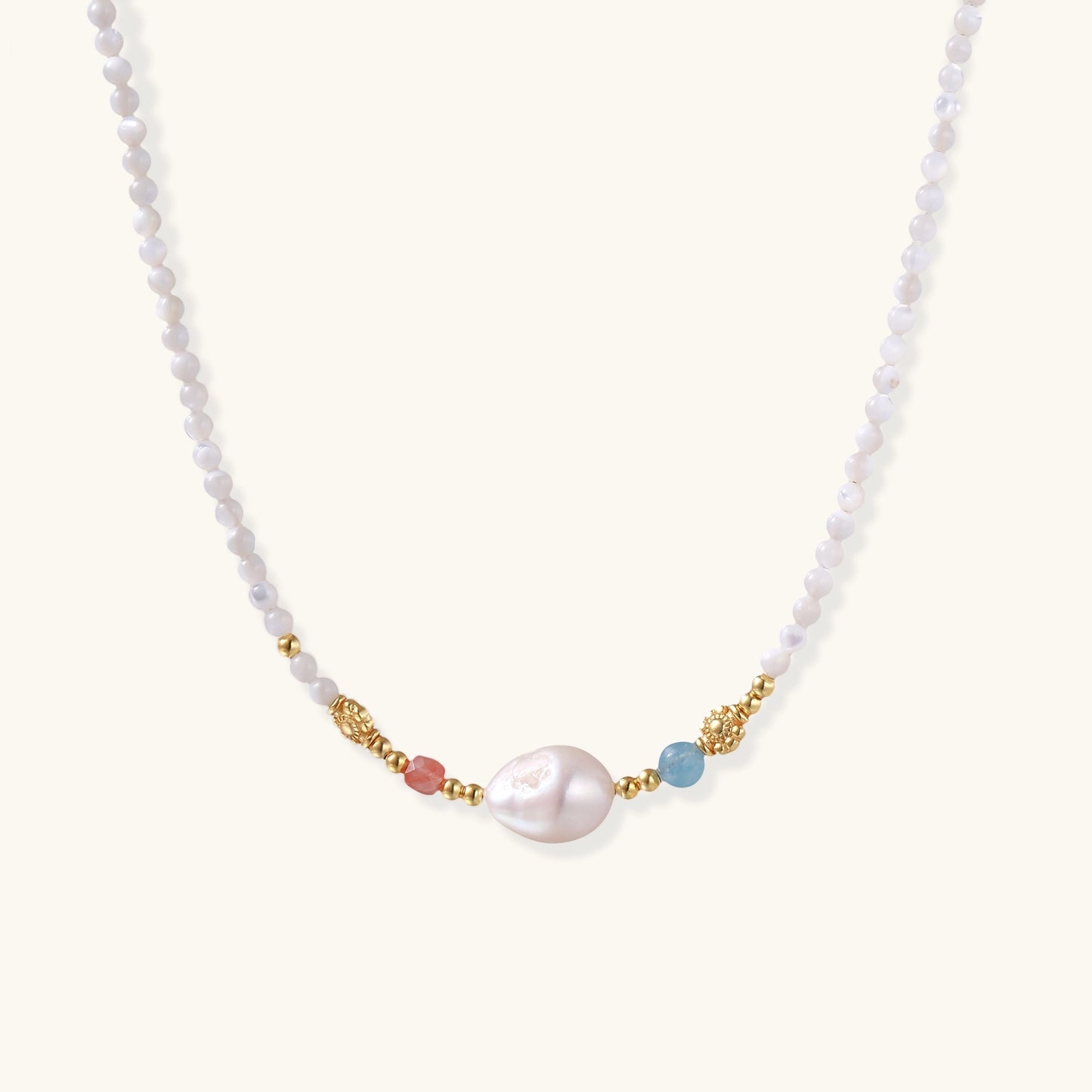 Delicate white beaded necklace with central freshwater pearl and gold-toned emerald accents on white background.
