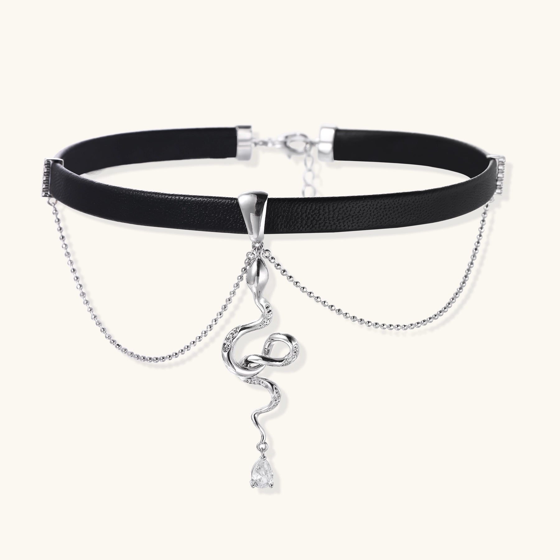 Black leather choker with gold-plated serpent pendant and crystal droplet on white background, adjustable chain design