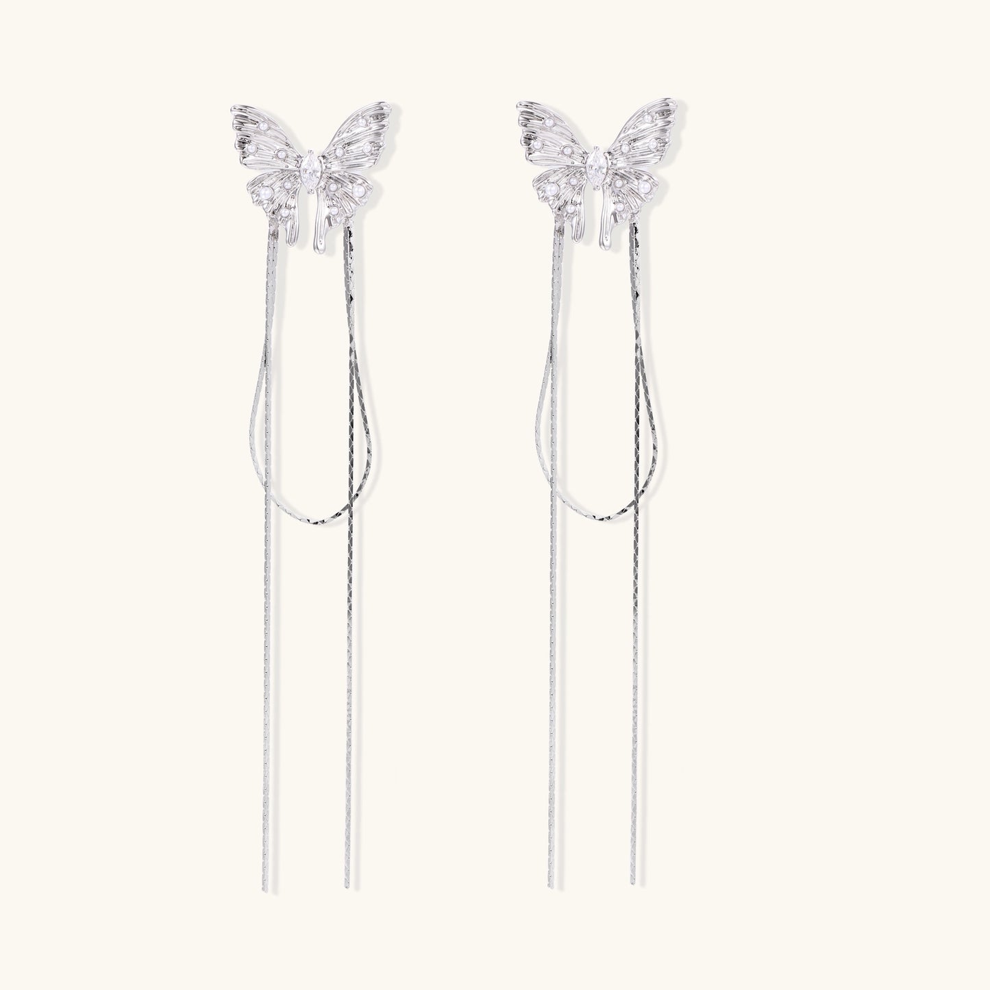 Delicate drop earrings with clear crystal butterfly tops and long metallic chain dangles on white background.