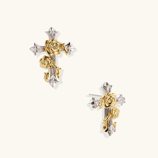 Two-tone cross earrings with gold roses and silver base featuring crystal accents on beige background.