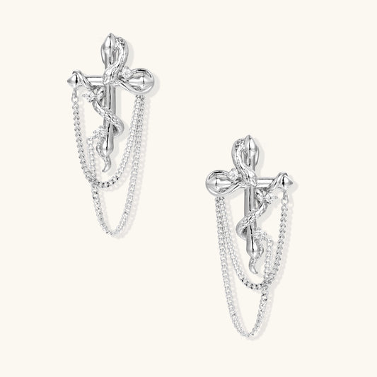 Silver-toned bow-shaped earrings with dangling chain details and zirconia accents on neutral background.