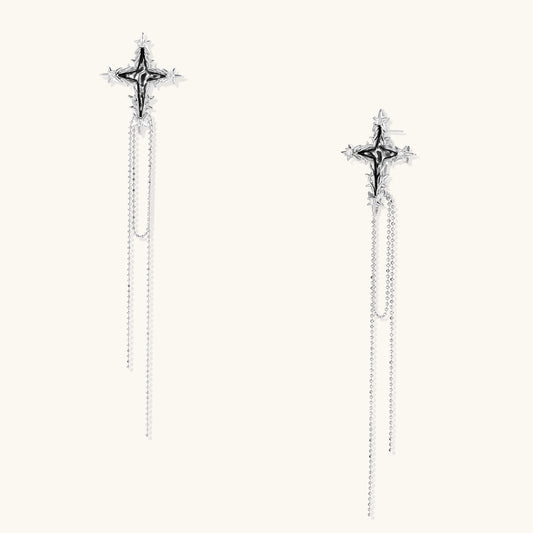 Long silver-toned cross earrings with star accents and delicate chain dangles on white background.