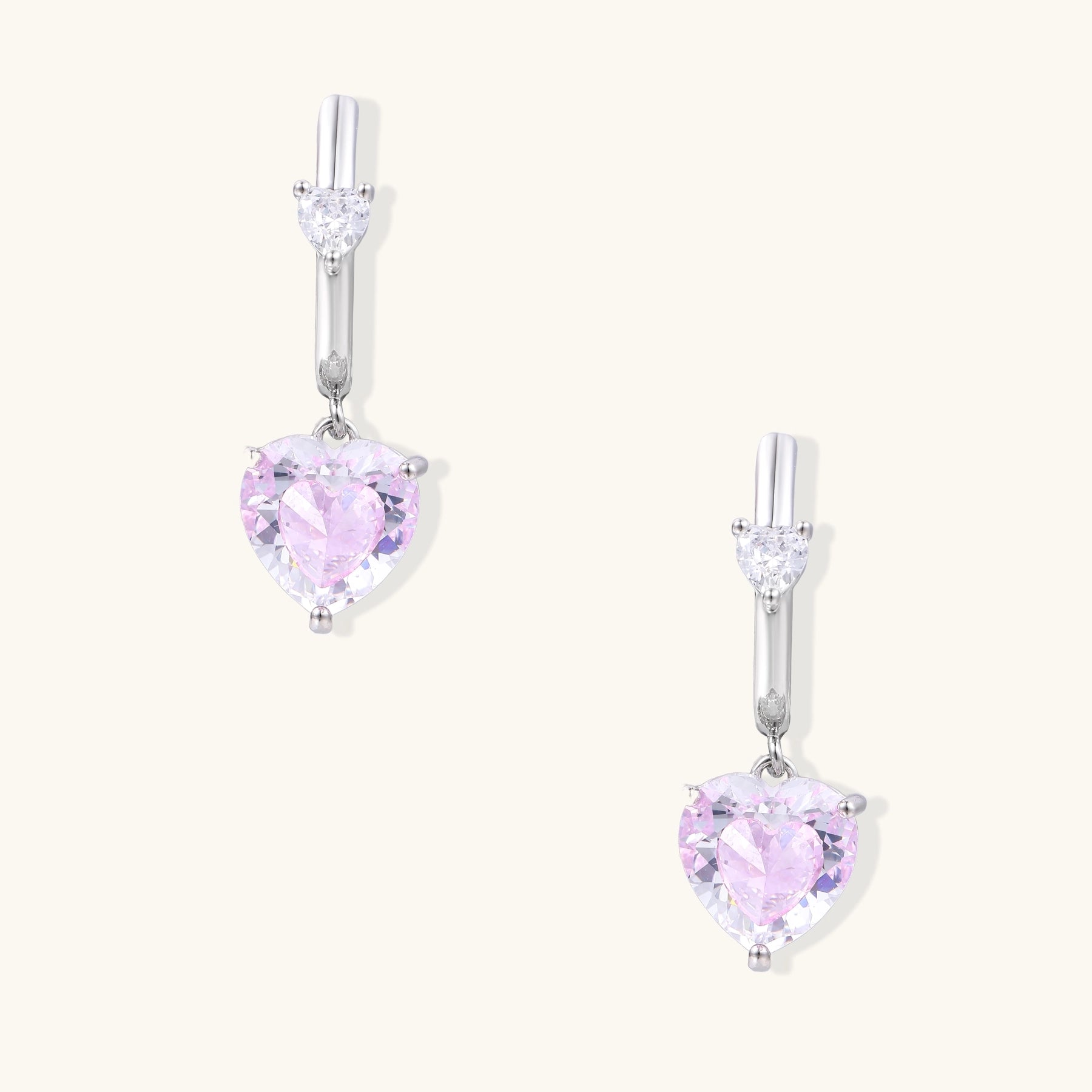 Elegant drop earrings featuring pink heart-shaped zirconia stones with clear accent gems in gold-plated settings