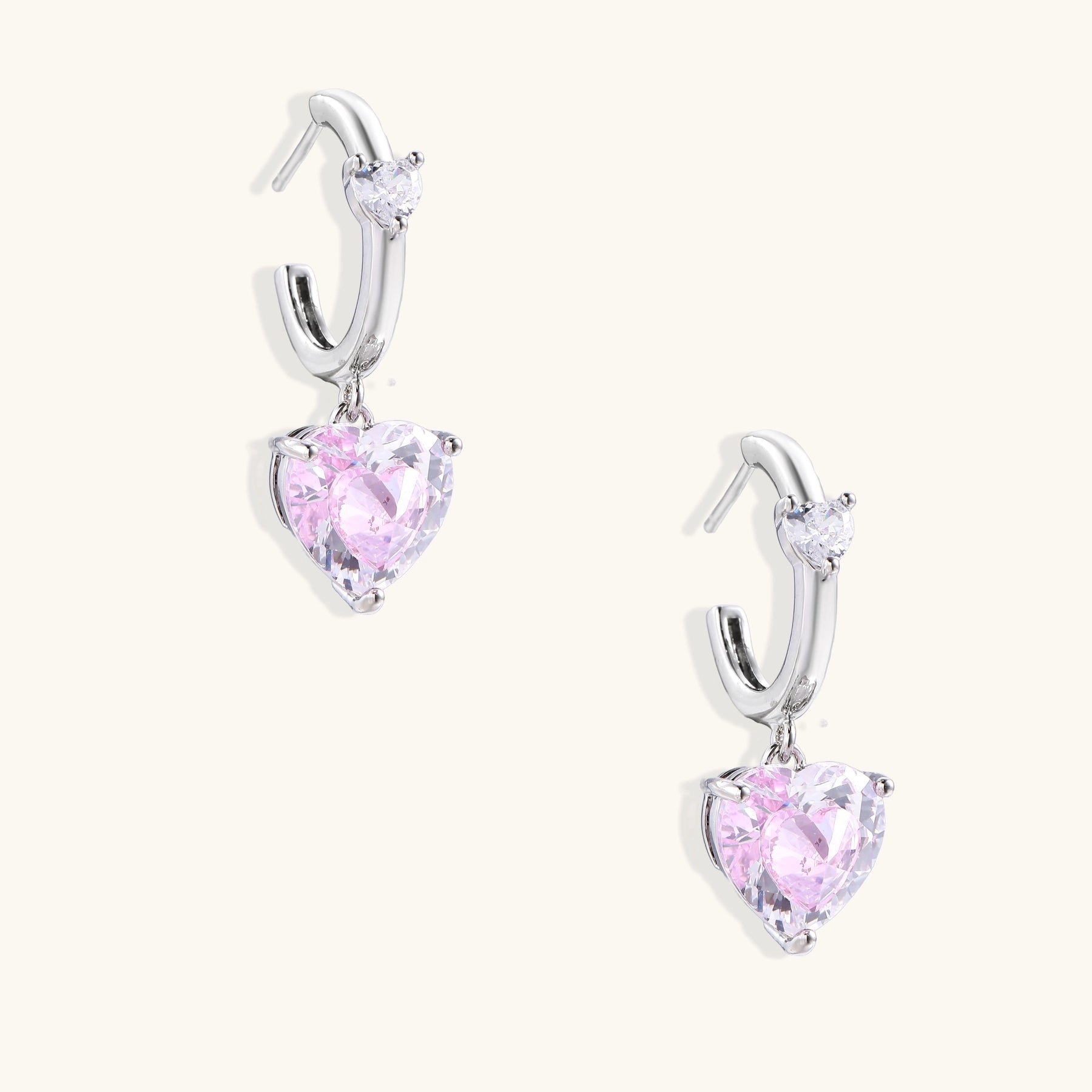 Elegant drop earrings featuring pink heart-shaped zirconia stones with clear accent gems in gold-plated settings