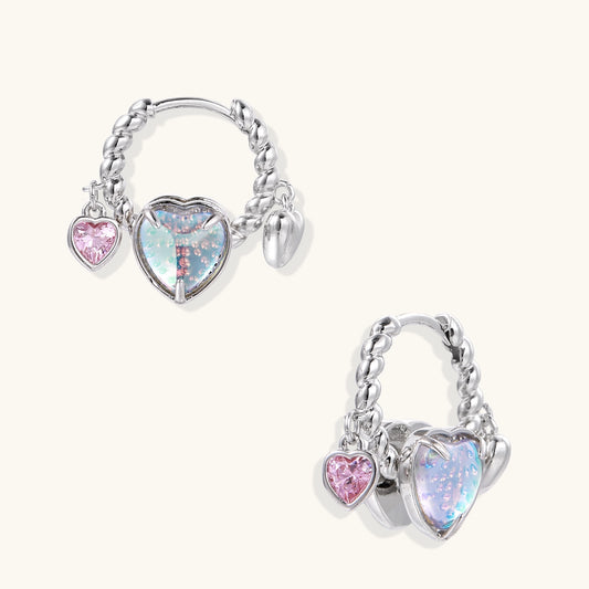 Gold-plated brass hoop earrings with three heart charms including iridescent turquoise and pink hearts on white background.
