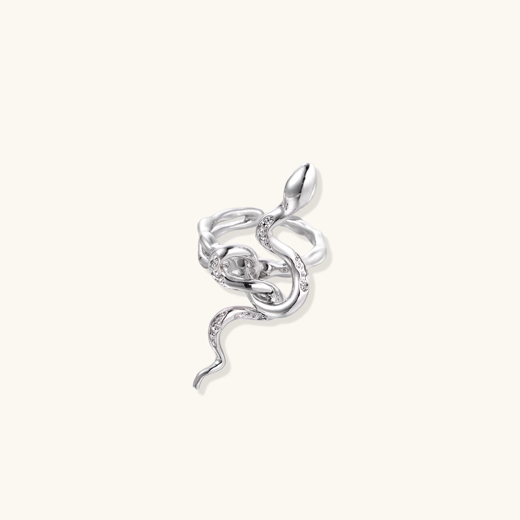 Gold-plated brass snake ring with flowing curves and crystal accents, wrapping around finger in sculptural design