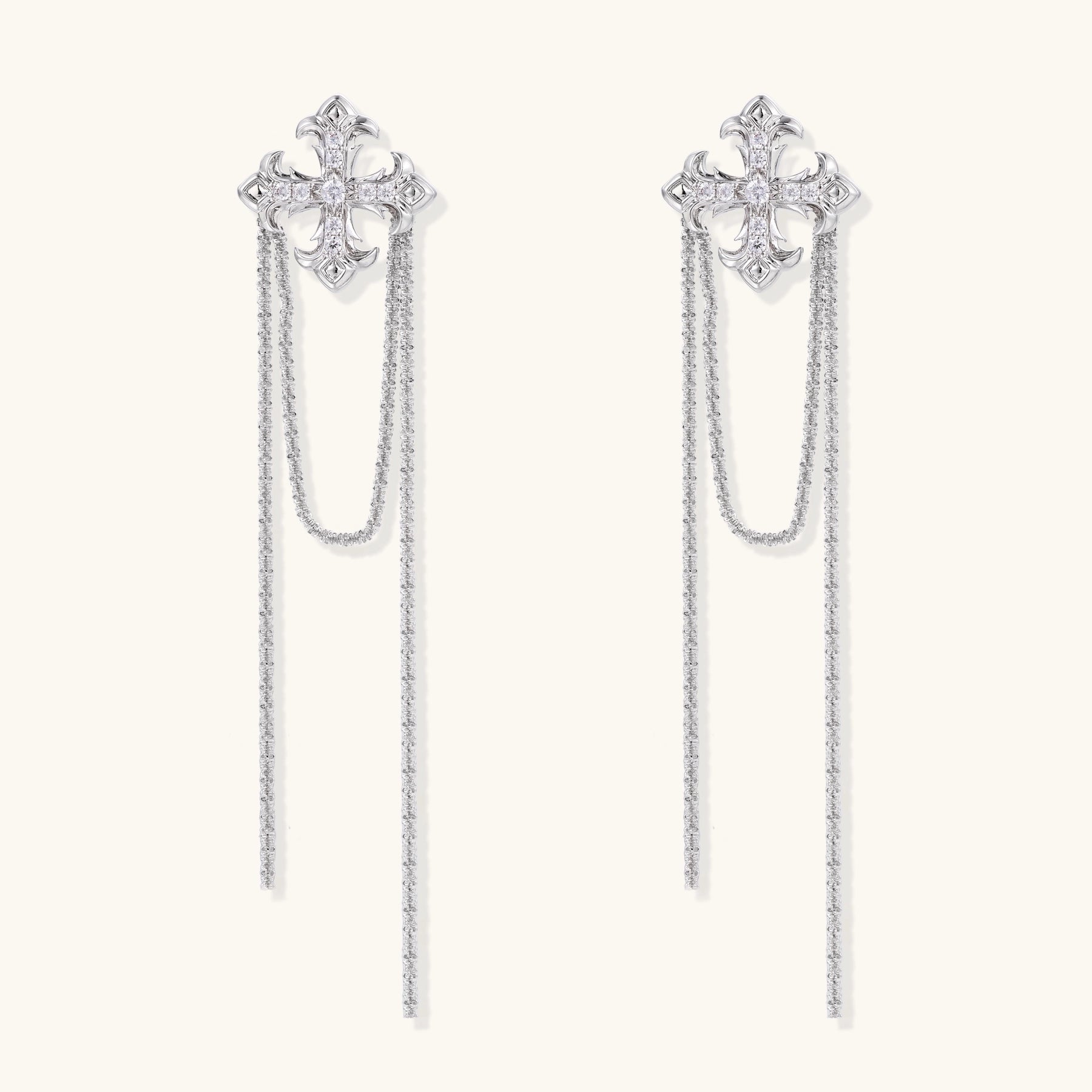 Ornate gold-plated cross earrings with zirconia crystals and flowing chain details on white background