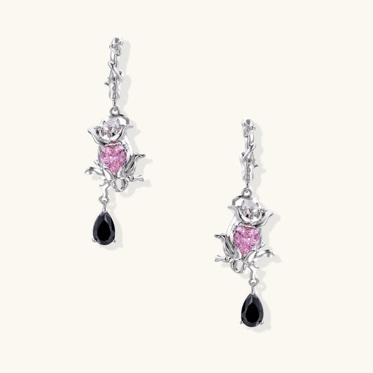 Gothic romantic dangle earrings featuring thorny rose design with pink zirconia and black teardrop elements on white background
