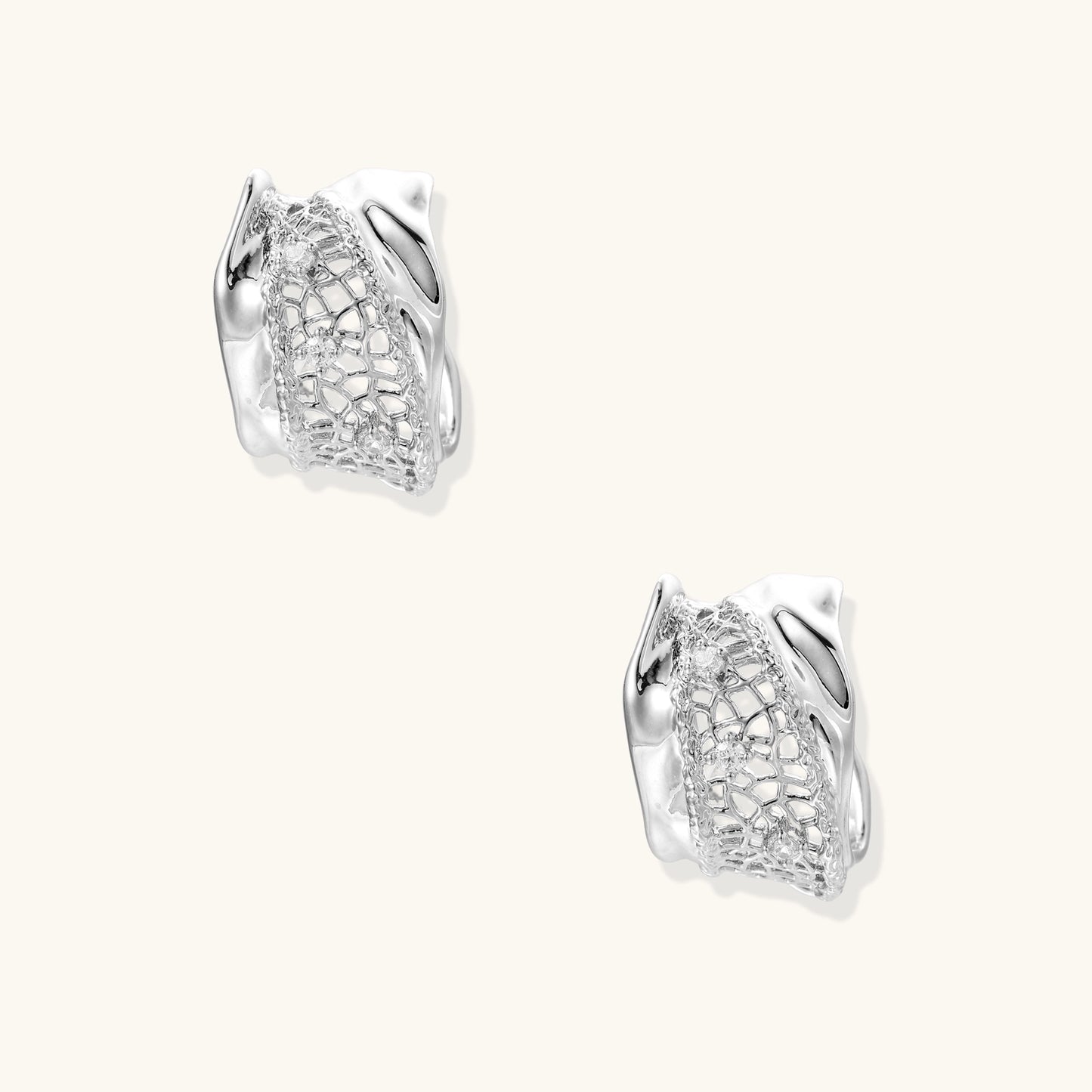 Small gold-plated brass hoop earrings with geometric lattice pattern and zirconia accents on white background.