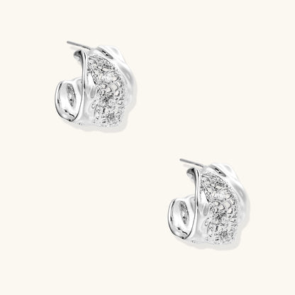 Small gold-plated brass hoop earrings with geometric lattice pattern and zirconia accents on white background.