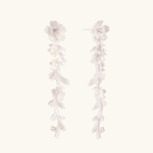 Pair of sterling silver dangle earrings with intricate leaf vine patterns and crystal accents on white background.