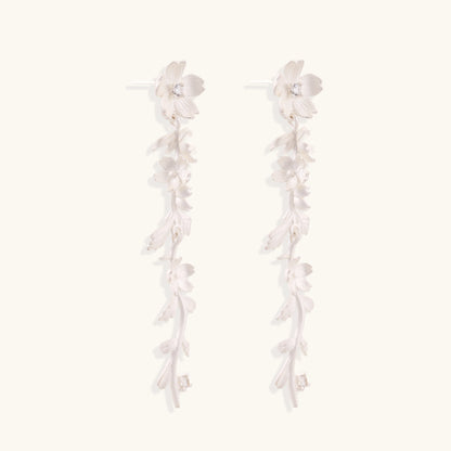 Pair of sterling silver dangle earrings with intricate leaf vine patterns and crystal accents on white background.
