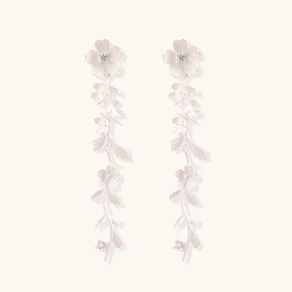 Pair of sterling silver dangle earrings with intricate leaf vine patterns and crystal accents on white background.