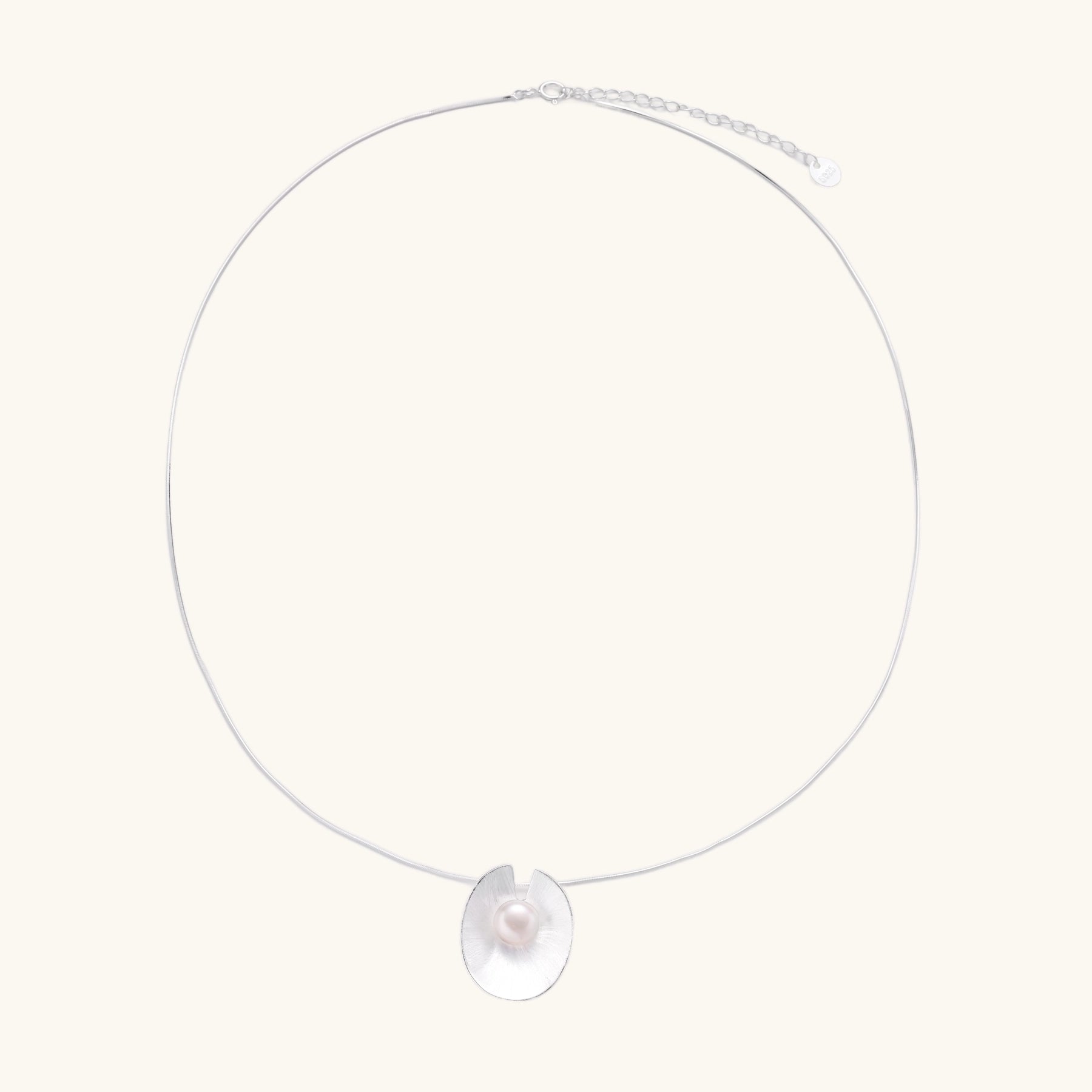 Delicate sterling silver necklace with oval iridescent pendant and central freshwater pearl on white background