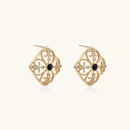 Ornate 18K gold plated stud earrings with intricate filigree design and central lapis lazuli stones on cream background.