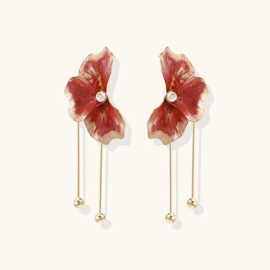 Statement drop earrings with coral-red enamel flower petals, gold-plated brass, and mother-of-pearl centers on white background