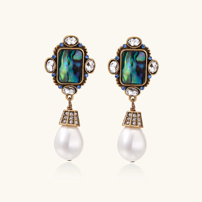 Gold-plated brass drop earrings featuring iridescent abalone shell centers, crystal accents, and white pearl drops.