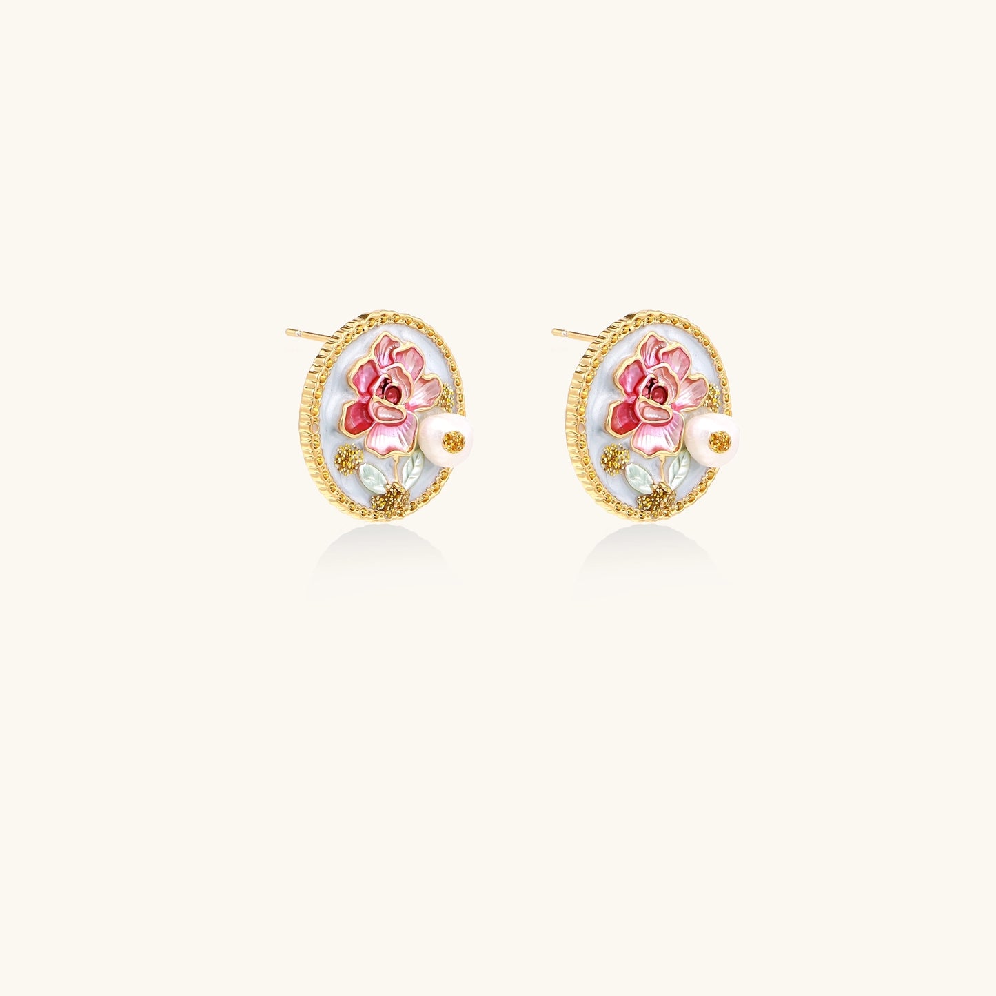 Round gold-plated stud earrings featuring pink enamel roses with freshwater pearl accents on white background.
