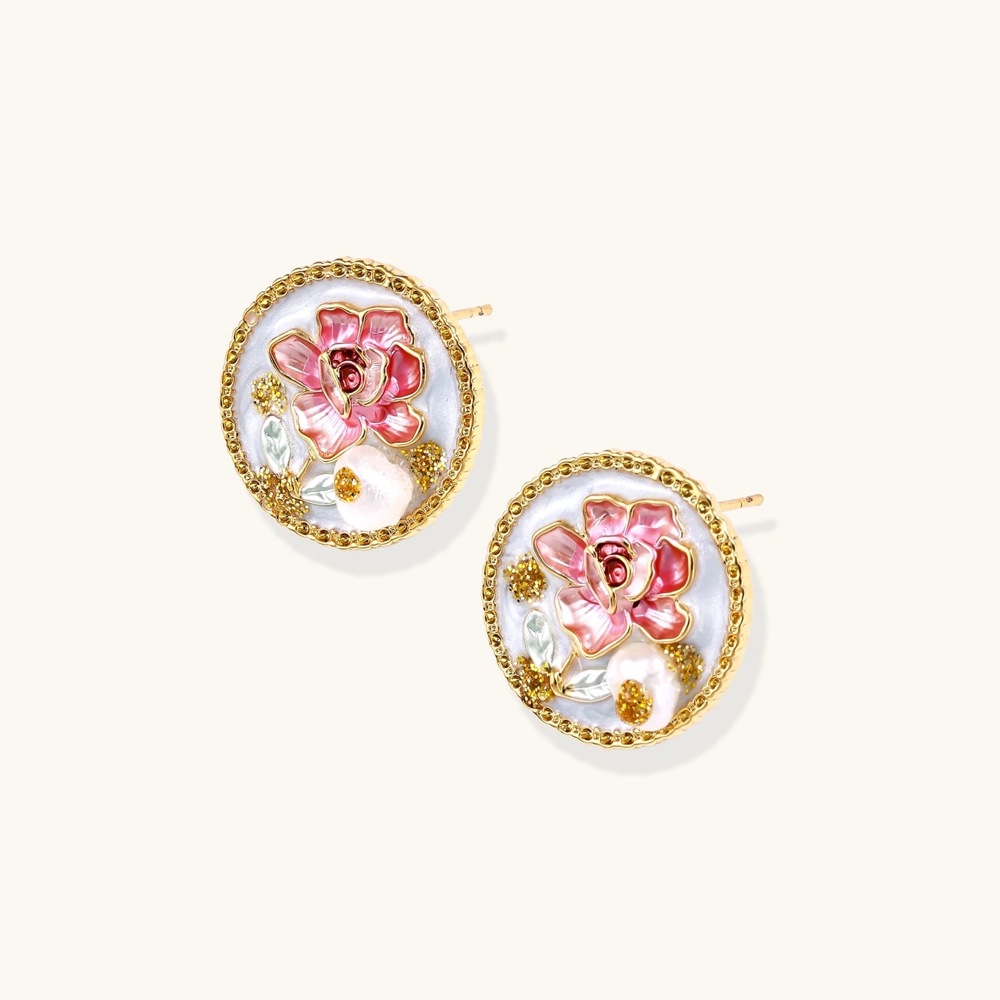Round gold-plated stud earrings featuring pink enamel roses with freshwater pearl accents on white background.