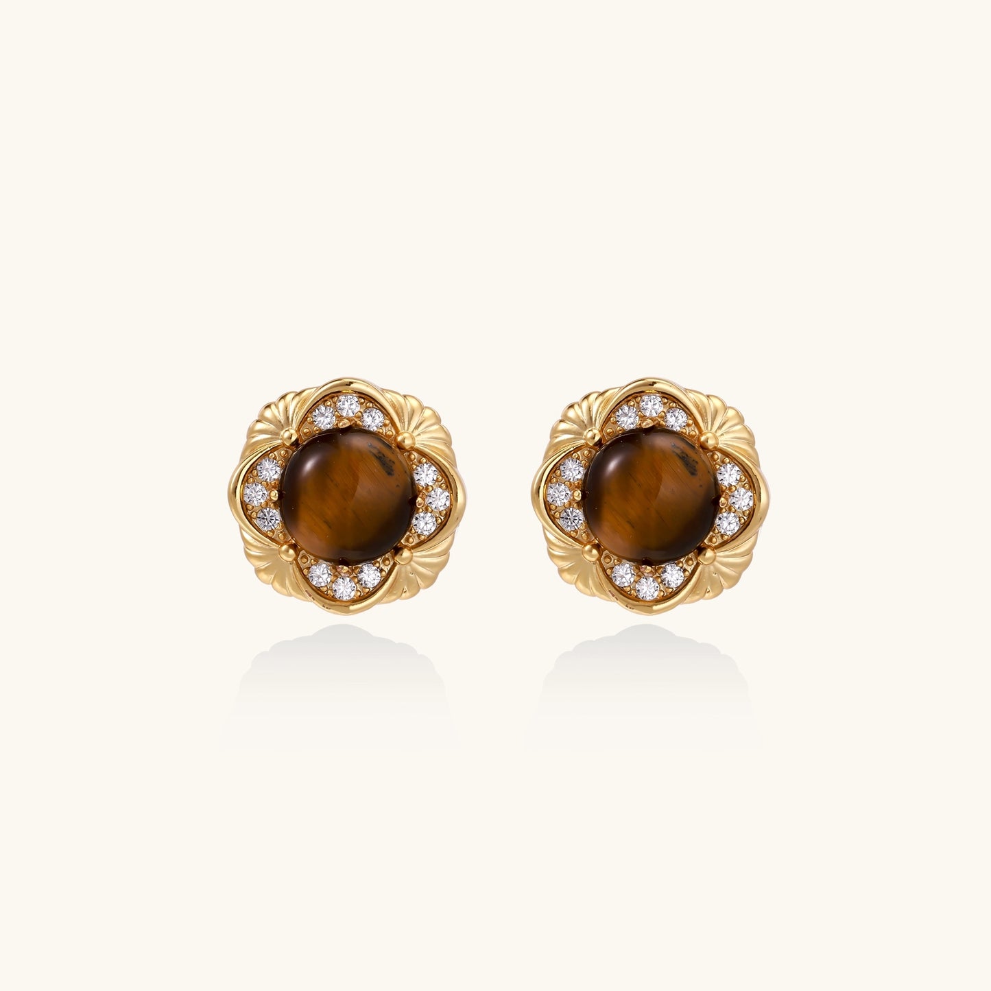 Ornate gold-plated brass stud earrings featuring round tiger's eye stones surrounded by sparkling zirconia in floral design