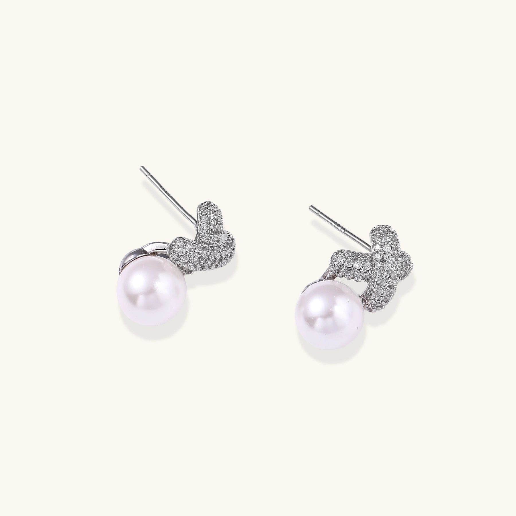 Elegant drop earrings with pavé crystal cross tops and round freshwater pearls on 14K gold plated brass setting.