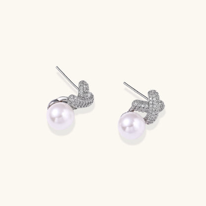 Elegant drop earrings with pavé crystal cross tops and round freshwater pearls on 14K gold plated brass setting.