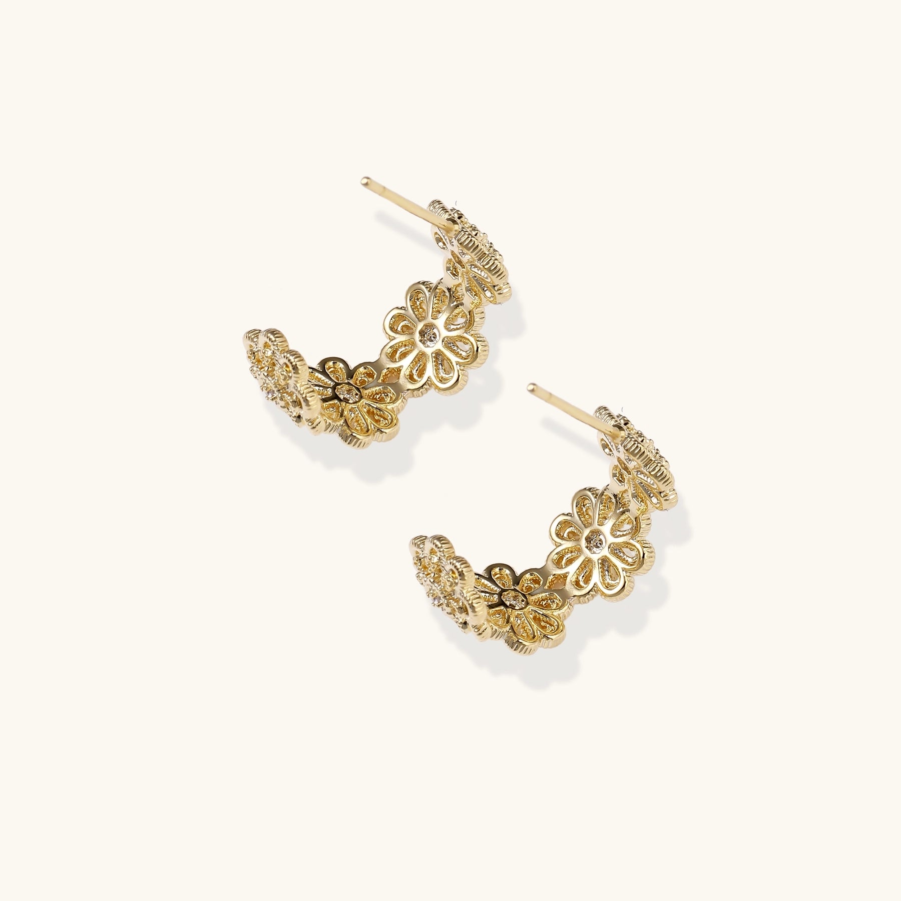 Ornate gold-plated brass hoop earrings featuring delicate floral filigree patterns and intricate rosette details.