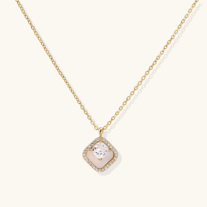 Gold-plated necklace with cushion-shaped pendant featuring a freshwater pearl surrounded by crystal halo on white background.