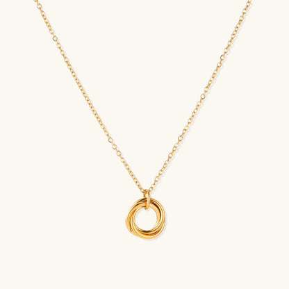 Close-up of a gold-plated stainless steel necklace with interlocking twisted ring pendant on white background