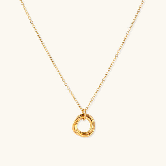 Close-up of a gold-plated stainless steel necklace with interlocking twisted ring pendant on white background