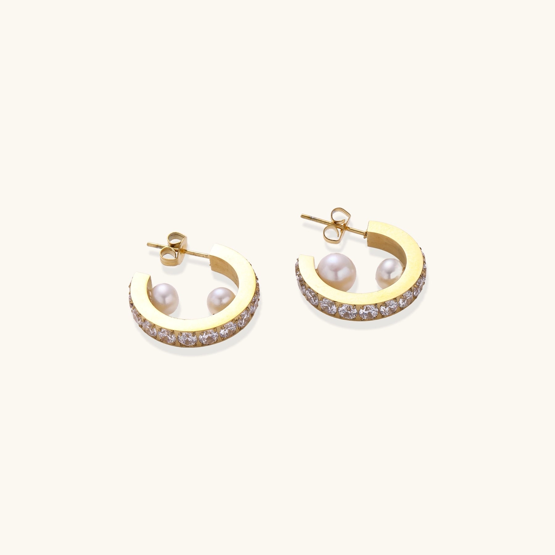 Gold-plated hoop earrings with crystal pavé and floating freshwater pearls inside the circular design.