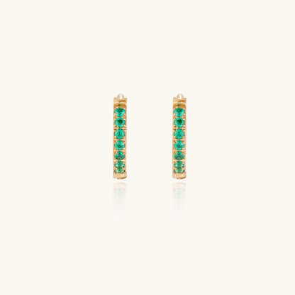Small gold-plated huggie hoop earrings with emerald green cubic zirconia stones, one open showing hinge mechanism