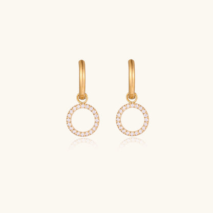 Gold-plated hoop earrings with circular cubic zirconia charm dangles displayed on neutral background.