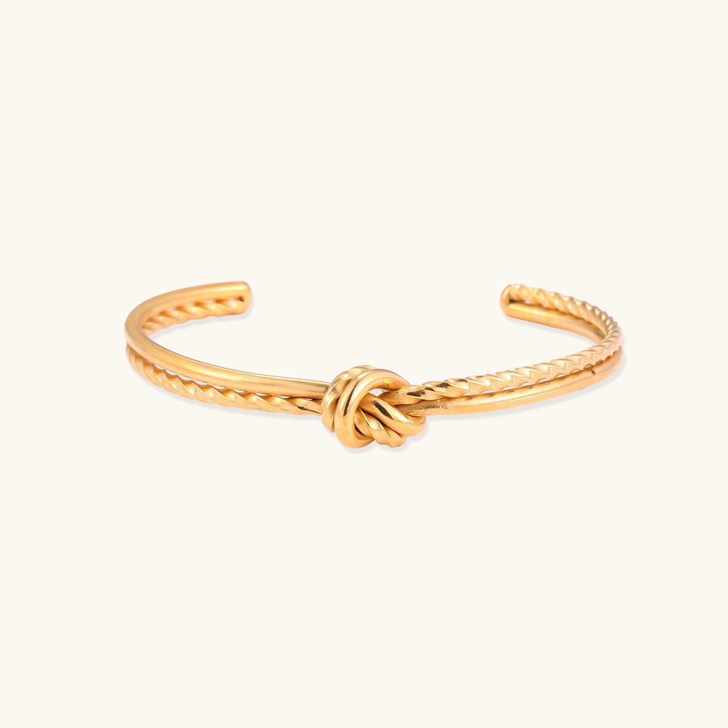 18K gold-plated twisted rope cuff bracelet with decorative knot detail on white background, showing adjustable open design.